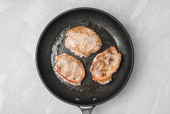 searing pork chops in a skillet