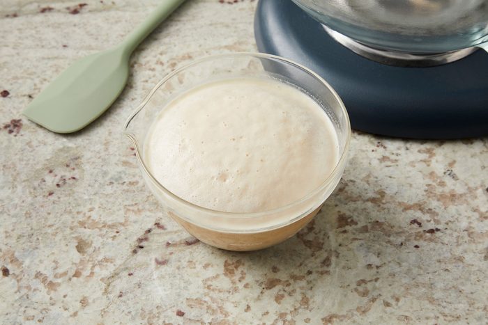 Foamy yeast activated in warm water in a small bowl.