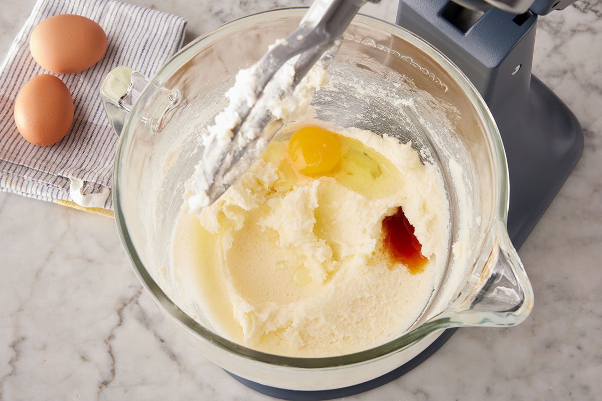 A egg is added in the mixture of softened butter and sugar in a stand mixer