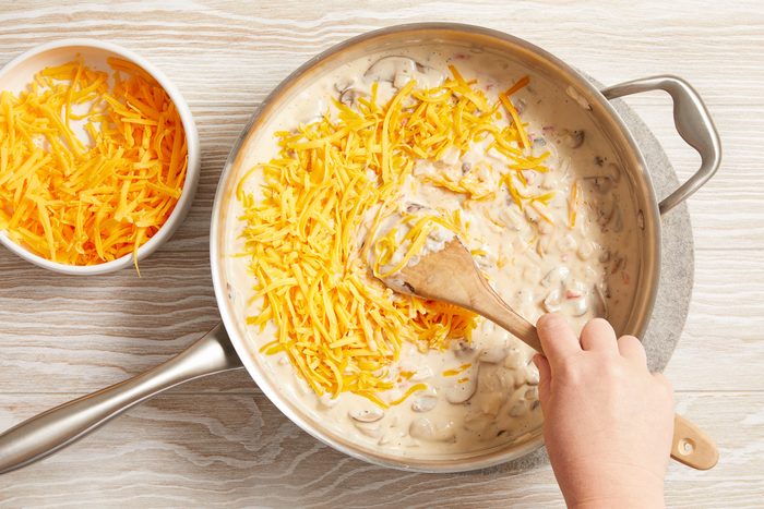 shredded cheddar cheese added to pan