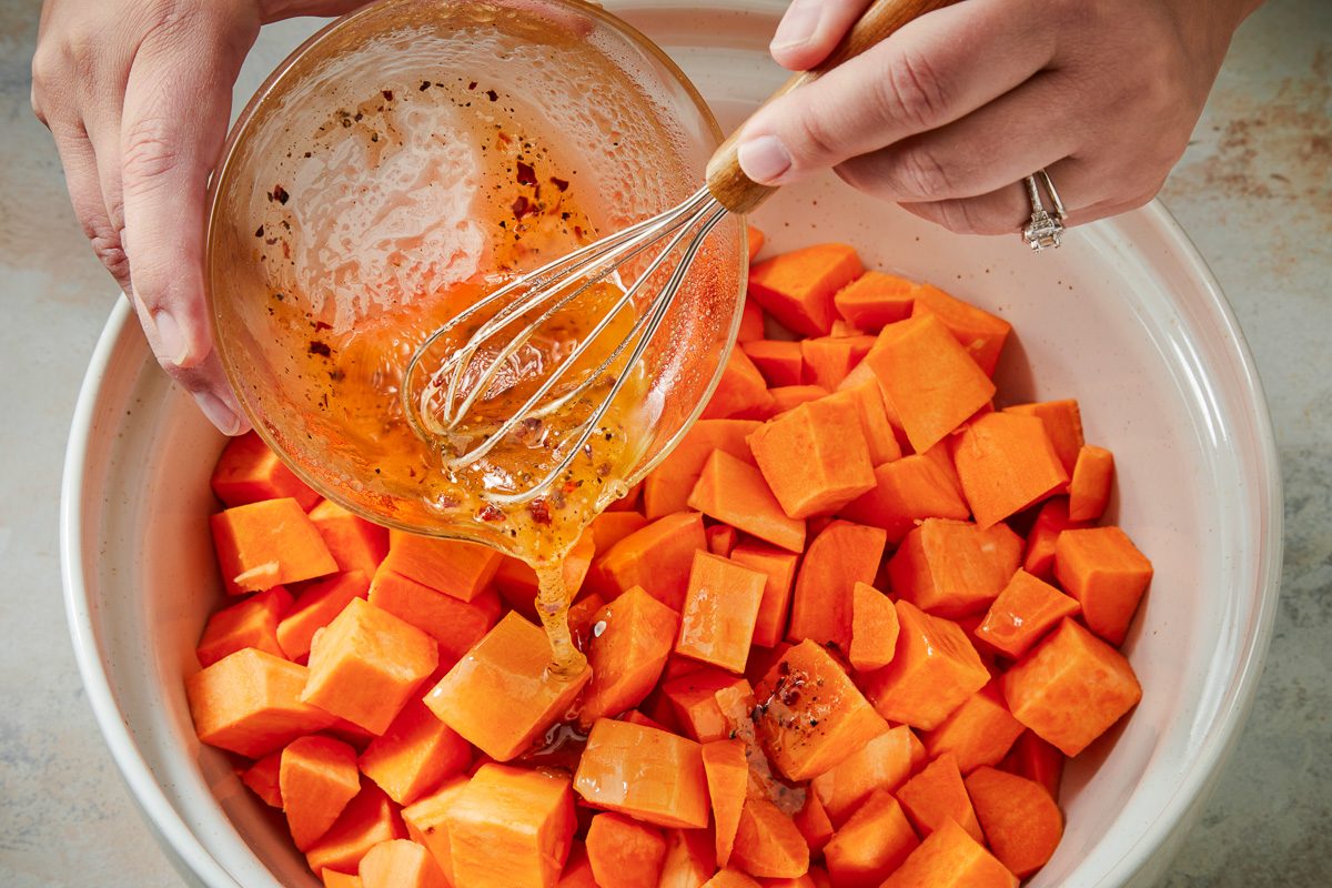 honey mixture being added to potatoes in a bowl