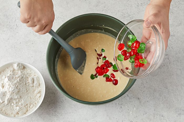 Mixing chopped candied fruit and flour to flour and eggs mixture to form a soft dough.