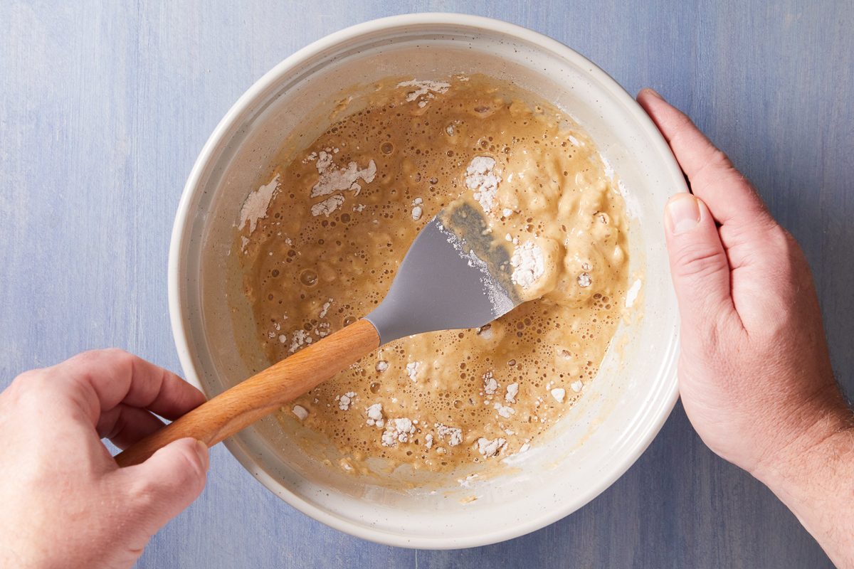 prepared pancake mix, molasses, cinnamon, ginger and cloves being whisked in a bowl