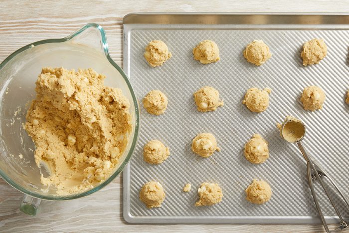 dough balls being placed on baking sheets