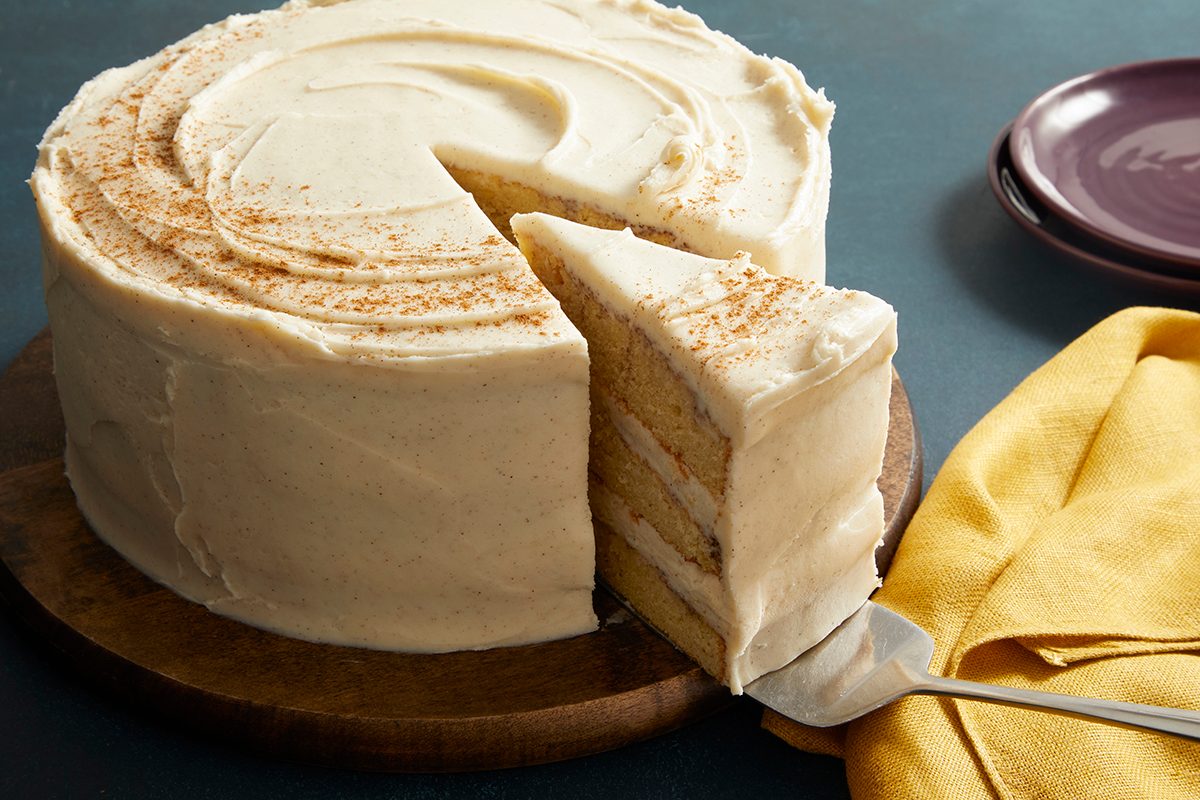 3/4 close-up of a Snickerdoodle Cake with a slice cut out, showing multiple cream-filled layers inside.