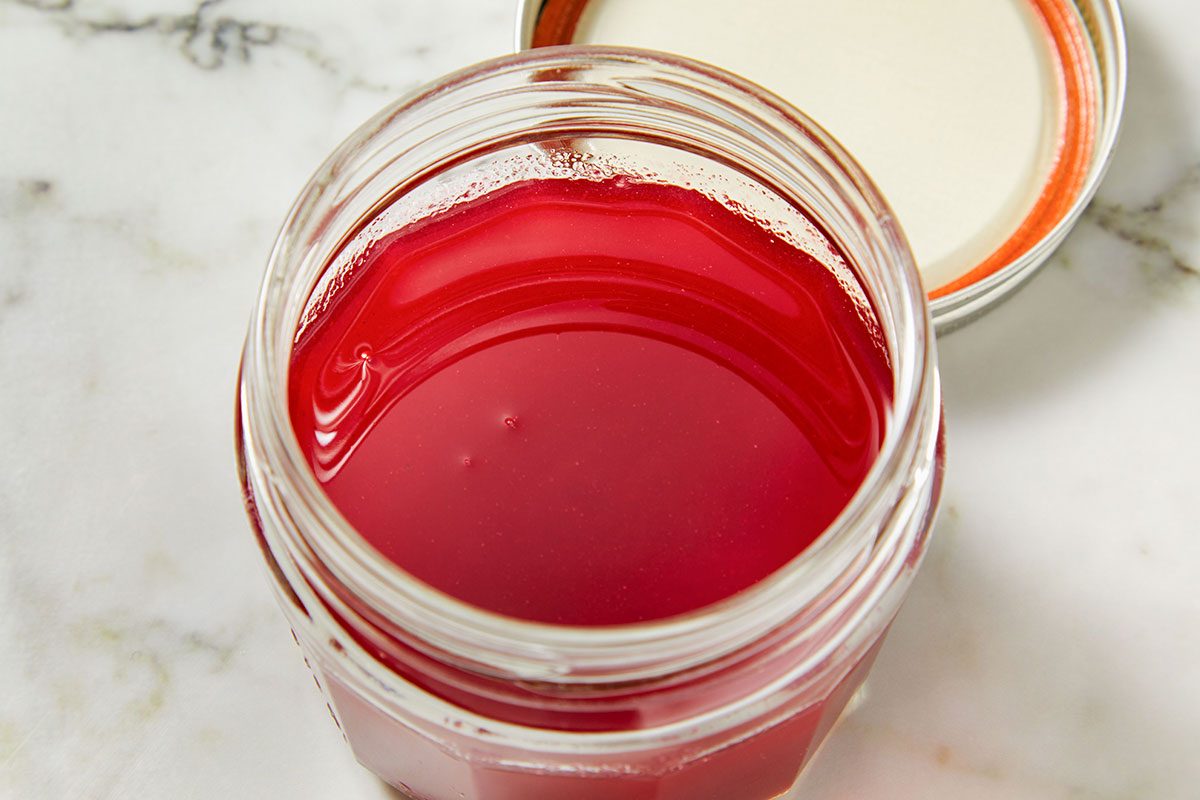 Overhead shot of a jar filled with freshly strained cranberry syrup